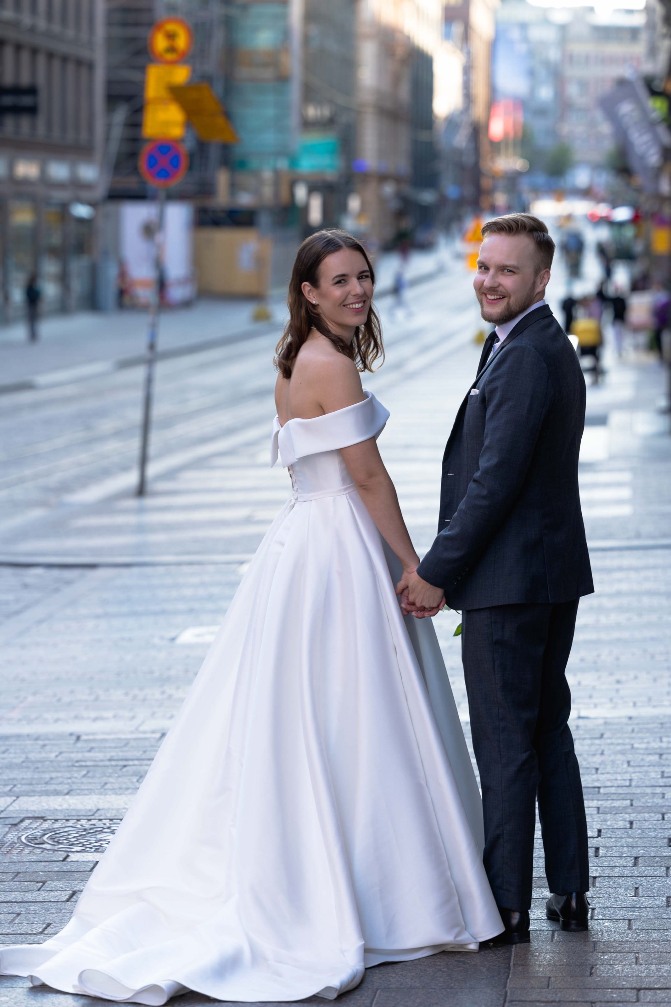 Bride and groom looking back on a city street